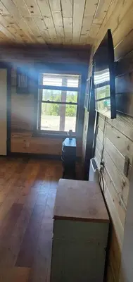 a living room of a tiny house with a window at Cowboy cabin in Grand Lake