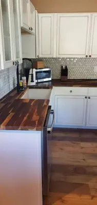 a kitchen with white cabinets and a wooden counter top at Cowboy cabin in Grand Lake