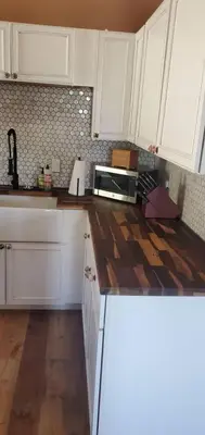 a kitchen with white cabinets and a wooden counter top at Cowboy cabin in Grand Lake
