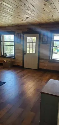 an empty room with a wooden floor and a door at Cowboy cabin in Grand Lake