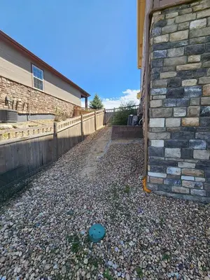 a house with a brick wall next to a driveway at Entire Basement with private Entrance within walking distance from the Gaylord hotel in Aurora