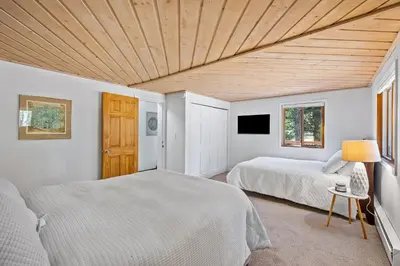 a bedroom with two beds and a wooden ceiling at Nestled Inn Vacation Home Rental Evergreen - Trails, Views, Hot Tub, Skiing! in Evergreen