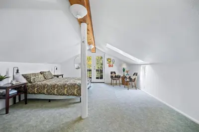 a bedroom with a bed and a table and chairs at Nestled Inn Vacation Home Rental Evergreen - Trails, Views, Hot Tub, Skiing! in Evergreen