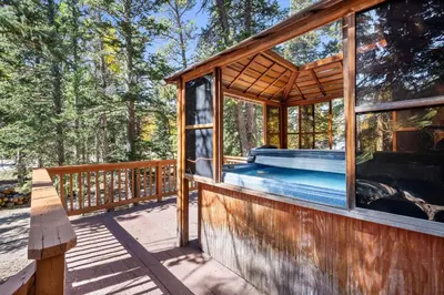 a wooden house with a swimming pool on a deck at Nestled Inn Vacation Home Rental Evergreen - Trails, Views, Hot Tub, Skiing! in Evergreen