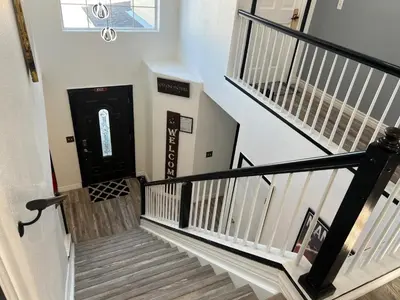 a hallway with stairs with a black door at DIA Layover B&B in DEN