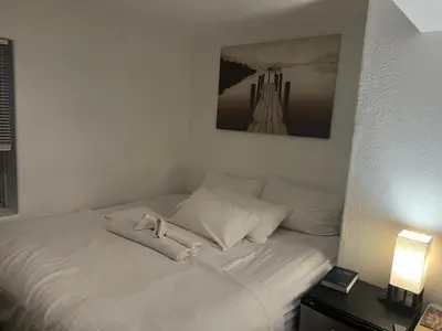 a white bed with white pillows and a picture on the wall at DIA Layover B&B in DEN