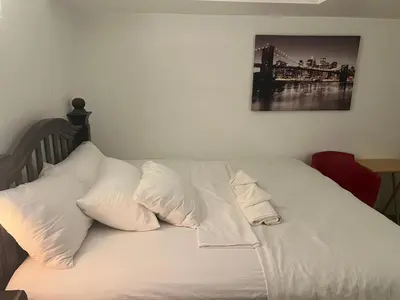 a bed with white sheets and pillows on it at DIA Layover B&B in DEN