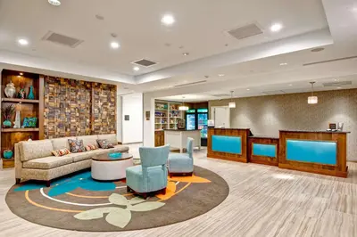 a lobby with a couch and chairs and a table at Homewood Suites by Hilton Greeley in Greeley