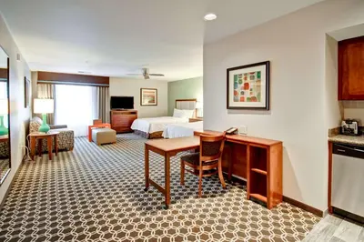 a hotel room with a bed and a desk at Homewood Suites by Hilton Greeley in Greeley