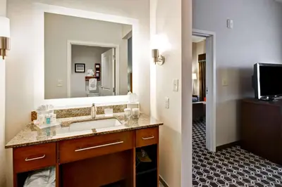 a bathroom with a sink and a large mirror at Homewood Suites by Hilton Greeley in Greeley