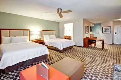 a hotel room with two beds and a desk at Homewood Suites by Hilton Greeley in Greeley
