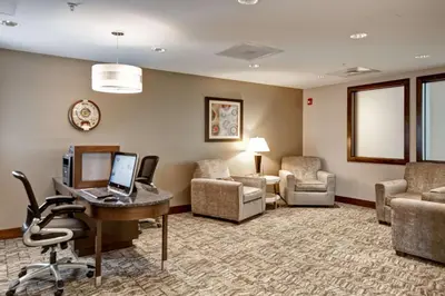 a hotel room with a desk with a computer and chairs at Homewood Suites by Hilton Greeley in Greeley