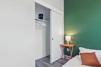 a bedroom with a green wall and a bed and a table at 3br W King Bed, Sauna, Parking-6 Min To Olde Town in Arvada