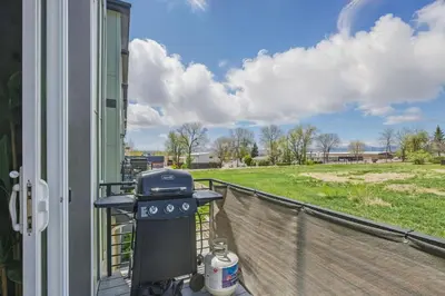 a grill on a balcony with a view of a field at 3br W King Bed, Sauna, Parking-6 Min To Olde Town in Arvada