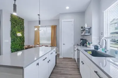 a large white kitchen with a sink and a counter at 3br W King Bed, Sauna, Parking-6 Min To Olde Town in Arvada