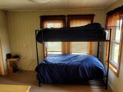 a bedroom with a bunk bed in a room with windows at Beautiful Cabin with Fire Pit and Deck in Foxpark, Wyoming in Foxpark