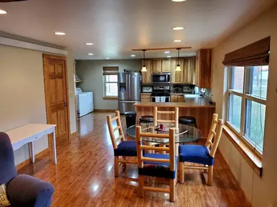 a kitchen with a table and chairs and a kitchen with a counter at Beautiful Cabin with Fire Pit and Deck in Foxpark, Wyoming in Foxpark