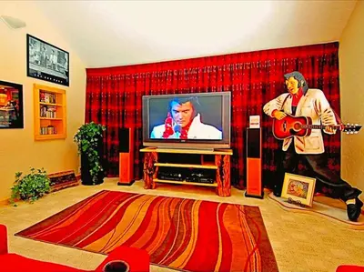 a living room with a tv with a man playing a guitar at Spacious Cabin with Breathtaking Views near Rocky Mountain National Park, Colorado in Estes Park