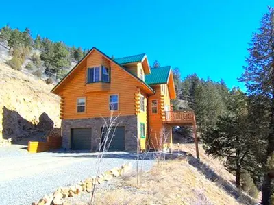 a large wooden house on top of a hill at Spacious Cabin Rental with a Hot Tub for a Weekend Getaway near Denver, Colorado in Idaho Springs