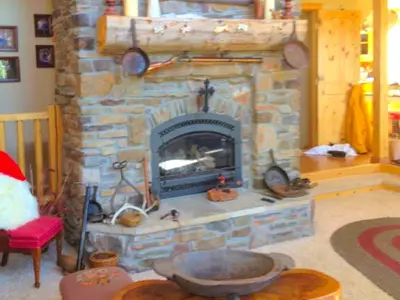 a stone fireplace in a living room with a fire place at Spacious Cabin Rental with a Hot Tub for a Weekend Getaway near Denver, Colorado in Idaho Springs