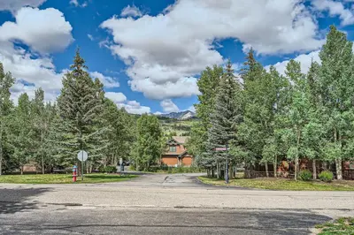 an empty street with trees and a house in the background at Cozy 1BR Near Trails with Shuttle to Slopes and Town in Breckenridge
