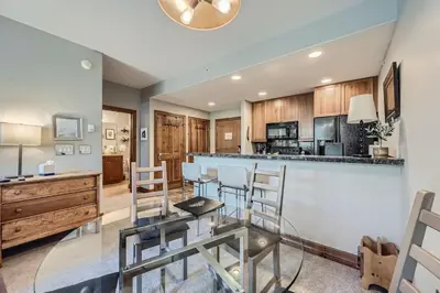 a kitchen with a bar and a dining room at Cozy 1BR Near Trails with Shuttle to Slopes and Town in Breckenridge
