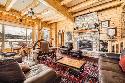 a living room with a stone fireplace in a log cabin at 3BDR with Loft for 8 Hot Tub Sauna & Mtn Views in Breckenridge