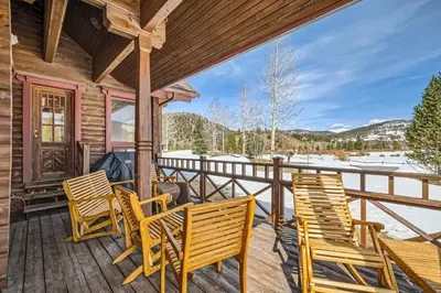 a deck with chairs and a grill on a cabin at 3BDR with Loft for 8 Hot Tub Sauna & Mtn Views in Breckenridge