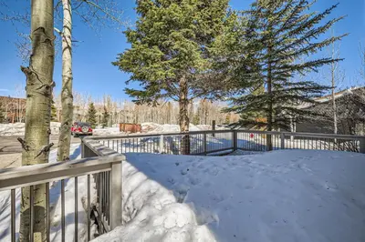 a snow covered yard with a fence and trees at Charming 3 BDR for 8 in the Heart of the Rockies in Frisco