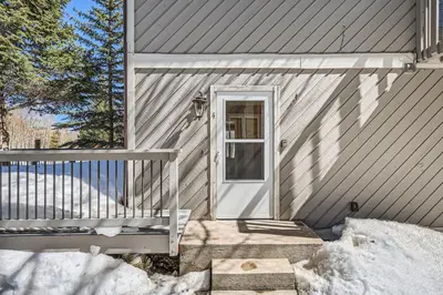 a gray house with a white door and stairs at Charming 3 BDR for 8 in the Heart of the Rockies in Frisco