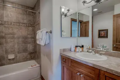 a bathroom with a sink and a toilet and a mirror at Spacious 4BR Near Trails with Shuttle to Slopes in Breckenridge