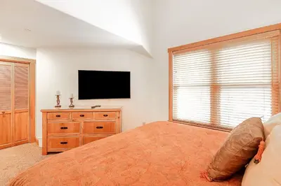 a bedroom with a bed and a flat screen tv at 3 BDR for 10 with Pool & Hot Tub Mins to Ski Lift in Dillon