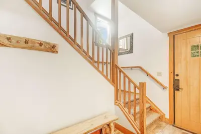 a staircase in a home with white walls and a wooden door at 3 BDR for 10 with Pool & Hot Tub Mins to Ski Lift in Dillon