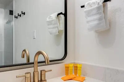 a bathroom with a sink and a mirror and towels at Rock Wren Poolside - 3 BDR Condo in Keystone