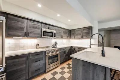 a kitchen with wooden cabinets and a sink and a microwave at Rock Wren Poolside - 3 BDR Condo in Keystone