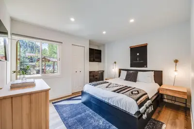a bedroom with a king sized bed and a window at Rock Wren Poolside - 3 BDR Condo in Keystone