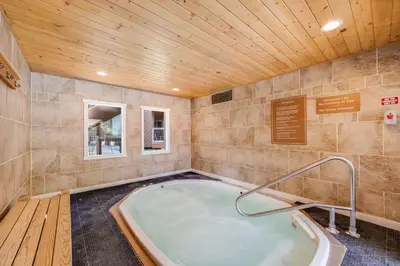 a hot tub in a room with a wooden ceiling at Rock Wren Poolside - 3 BDR Condo in Keystone
