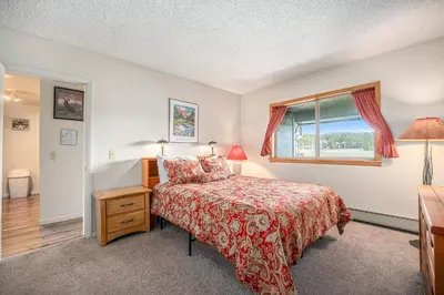 a bedroom with a bed and a window at Townhouse w hot tub, gym & pool in Fraser