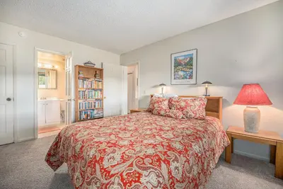 a bedroom with a bed with a red bedspread at Townhouse w hot tub, gym & pool in Fraser