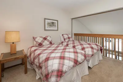 a bedroom with a bed and a table with a lamp at Meadow Ridge Court 31 Unit 4 in Fraser