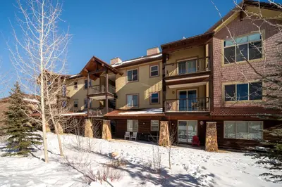 a large apartment building in the snow with trees at Trailhead Lodges Building 701 Unit 731 in Winter Park