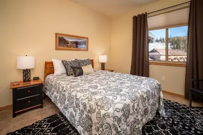 a bedroom with a bed and a large window at Trailhead Lodges Building 701 Unit 731 in Winter Park