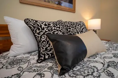 a bed with black and white pillows on it at Trailhead Lodges Building 701 Unit 731 in Winter Park