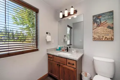 a bathroom with a sink and a toilet and a mirror at Townhome on Vasquez Creek #8 in Winter Park