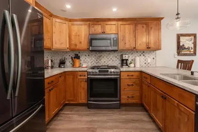 a kitchen with wooden cabinets and stainless steel appliances at Townhome on Vasquez Creek #8 in Winter Park