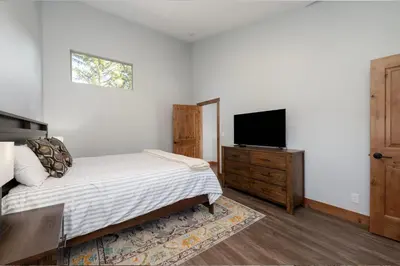 a bedroom with a bed and a flat screen tv at Townhome on Vasquez Creek #8 in Winter Park