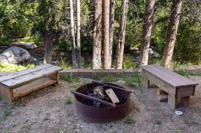 two benches and a fire pit next to a picnic table at Townhome on Vasquez Creek #8 in Winter Park
