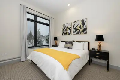 a white bedroom with a bed and a window at Timber Fox Building B Unit 2102 in Winter Park
