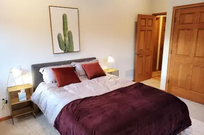 a bedroom with a large bed with two red pillows at Luxurious Rocky Mountain Retreat above Boulder in Nederland