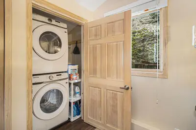a laundry room with a washer and dryer next to a door at Cedar Ridge Sanctuary Rocky Mtn Natl Park in Lyons